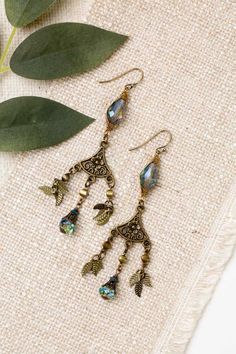 Mindfully crafted, these earrings from the Crisp Autumn collection offer a stylish and eye-catching way to accessorize. Perfect for pairing with other pieces from the line. Antique Brass (lead and nickel free) Czech Glass 3", with antique brass ear wires We hand select our natural materials, thus there may be slight variations in color and/or size that will not detract from the overall aesthetic Our unique handcrafted designer jewelry for women is made in America, with each design created indivi Nickel-free Bronze Chandelier Earrings, Nickel Free Brass Chandelier Earrings With Long Drop, Metal Chandelier Earrings With Dangling Charms As Gift, Nickel-free Metal Drop Crystal Earrings, Silver Gold Earrings, Silver Gold Necklace, Simple Collage, Designer Handmade Jewellery, Handcrafted Bracelets