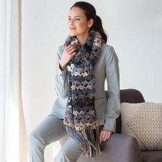 a woman sitting on a couch wearing a scarf