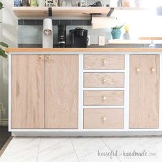 a kitchen with wooden cabinets and white tile flooring, along with shelves on the wall