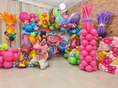 a man sitting on the floor in front of balloons