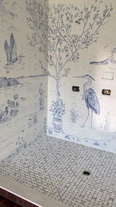 the shower is decorated with blue and white wallpapers, including birds on it