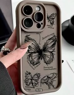 a person holding up an iphone case with butterflies on it and the phone cover has been drawn