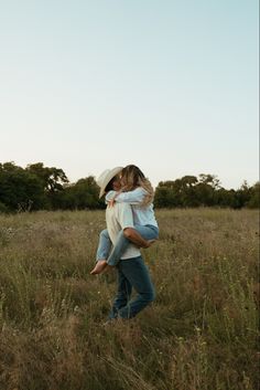 two people are walking through the tall grass