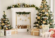 christmas trees and presents are arranged in front of a fireplace with gold ornaments on it