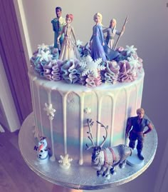 a frozen princess cake with figurines on top