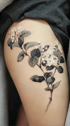 a woman's thigh with flowers and leaves on it