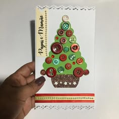 a hand holding a christmas card with buttons on it