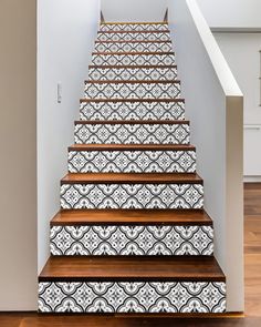 the stairs are decorated with black and white tile designs, along with wood flooring