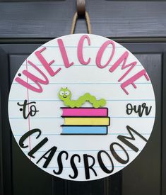 a welcome to our classroom sign hanging on the front door with writing and an image of a caterpillar