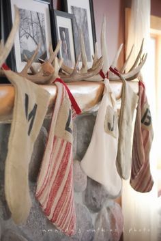 stockings hung on a mantle with deer antlers hanging from it's sides and pictures above them