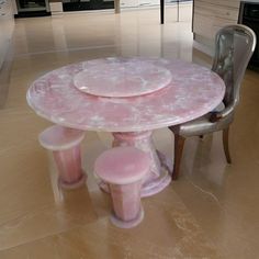 a table and chairs in a room with marble flooring that looks like it has been painted pink