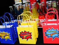 colorful paper bags on display for sale at a store or event with soda bottles in the background