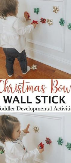 a toddler playing with christmas bow wall stickers