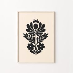 a black and white print with flowers on it's side, hanging on a wall