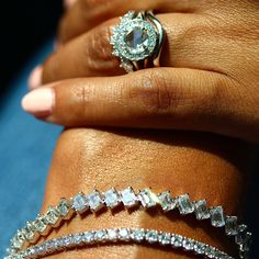 a woman's hand with three different rings and bracelets on her left wrist