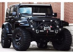 a black jeep parked in front of a brick building