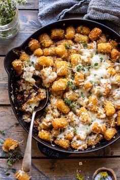 a skillet filled with tater tots covered in cheese and parmesan