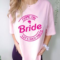 a woman wearing a pink t - shirt that says come on bride let's bach party