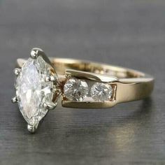 an engagement ring with three stones on the side, and a diamond in the middle