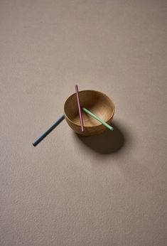 two straws in a wooden bowl on a table