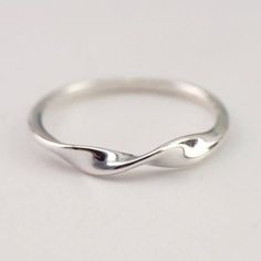 an image of a silver ring with waves on it's sides and the top half of