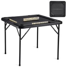 the folding table has two books on it and is black with gold trimmings