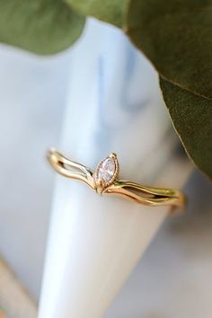 a close up of a ring on a white napkin next to a plant with green leaves