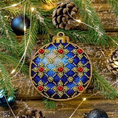 an ornament hanging from a christmas tree with pine cones and ornaments around it