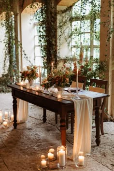 the table is set with candles and greenery for an elegant dinner or wedding reception