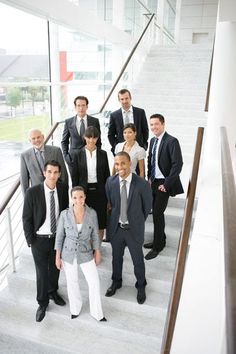 a group of business people are standing on the stairs