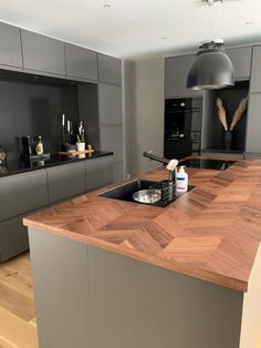 a modern kitchen with an island and wooden counter tops in the center, along with stainless steel appliances