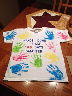 a t - shirt that says hands down and 100 days smarter on it, sitting on a table