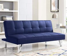 a blue futon sofa sitting on top of a white rug in a living room