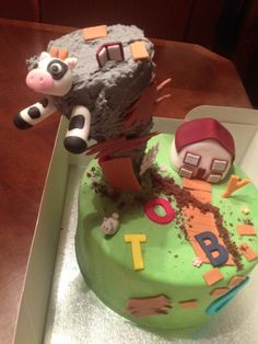 a birthday cake with a cow and farm animals on it's side in a box