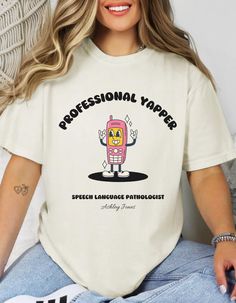 📞 Professional Yapper Speech Therapist Shirt 🎤 Celebrate your gift of gab with this adorable Professional Yapper shirt, perfect for speech therapists who love what they do! Featuring a cute retro cell phone character and the fun phrase "Professional Yapper," this shirt is both playful and professional. Plus, you can customize it with your name to make it uniquely yours! 📞 Features: Retro cell phone character design with the words "Professional Yapper" Customizable with your name for a persona Professional Yapper, Tshirt Aesthetic, Speech Therapy Shirts, Speech Language Pathologist, Speech Therapist, Vogue Covers, Speech Language Pathologists, Speech Therapy, Looks Vintage