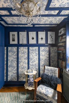 a blue and white room with a chandelier hanging from the ceiling