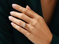 a woman's hand with a diamond ring on it