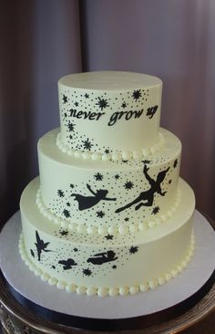 a three tiered cake decorated with black and white frosting, stars and tinsels