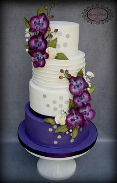 a three tiered cake with purple flowers on it