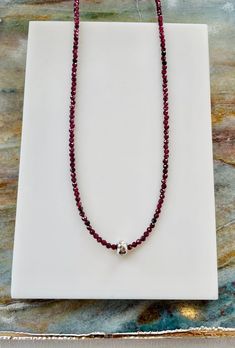 This necklace combines  a beautiful deep wine red strand of tiny faceted red garnet beads with a large holed, hammered sterling silver bead that floats or slides over the garnet beads. Strung on a sterling silver lobster clasp.  This little necklace gives you a lot of bang for your buck with a bright pop of color and a flash of silver.it can easily be worn dressed up or down.  Measures approximately 16-18 inches  Stone beads measure approximately 2-2.5mm Silver bead measures approximately 5 x 8mm Matching accessories available.  Inquire for custom orders. Bright Pop, Hammered Sterling Silver, Matching Accessories, Silver Bead, Garnet Gemstone, Red Garnet, Sterling Silver Bead, Wine Red, Silver Beads