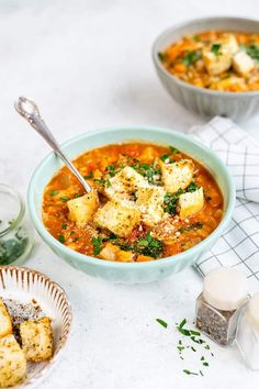 two bowls of soup with tofu and parmesan bread on the side,