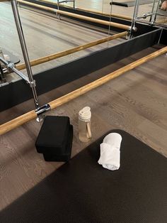 an empty black mat and some white napkins on the floor in front of a mirror