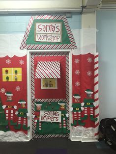 an office decorated for christmas with santa's workshop on the front door and candy shop on the side