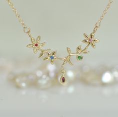 "This 14K gold flower necklace is a perfect love gift. This gold necklace and gemstone is a solid gold chain and pendant. That unique pendant is 3 small flowers and leaf and a tiny gold teardrop. Every small flower has a little gemstone in the center. The tiny teardrop has a marquise, Ruby. You can wear this unique gold necklace every day with every look. You can ask for different gemstones in the center of the flowers and in the little drop. Please let me know the length of the chain that you w Gold Gemstone Necklaces With Flower Design, Yellow Gold Flower Necklace With Gemstone, Yellow Gold Flower Shaped Gemstone Necklace, 14k Gold Necklace With Gemstone Flower Pendant, Yellow Gold Birthstone Necklace With Flower Pendant, Yellow Gold Gemstone Necklace In Flower Shape, Yellow Gold Flower-shaped Gemstone Necklace, Elegant Gold Birthstone Necklace With Flower Charm, Flower Shaped Necklace With 17 Jewels For Gift