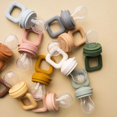 many different colored baby pacifiers on a table