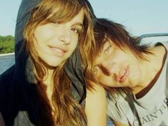 two young people are posing for a photo in the back of a car with their arms around each other