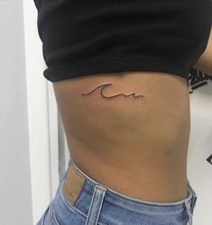 a woman with a small wave tattoo on her stomach