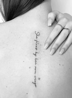 the back of a woman's shoulder with writing on it