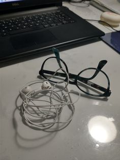 a pair of glasses sitting on top of a table next to a laptop