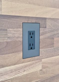 an electrical outlet on a wooden wall with wood grained walls in the back ground